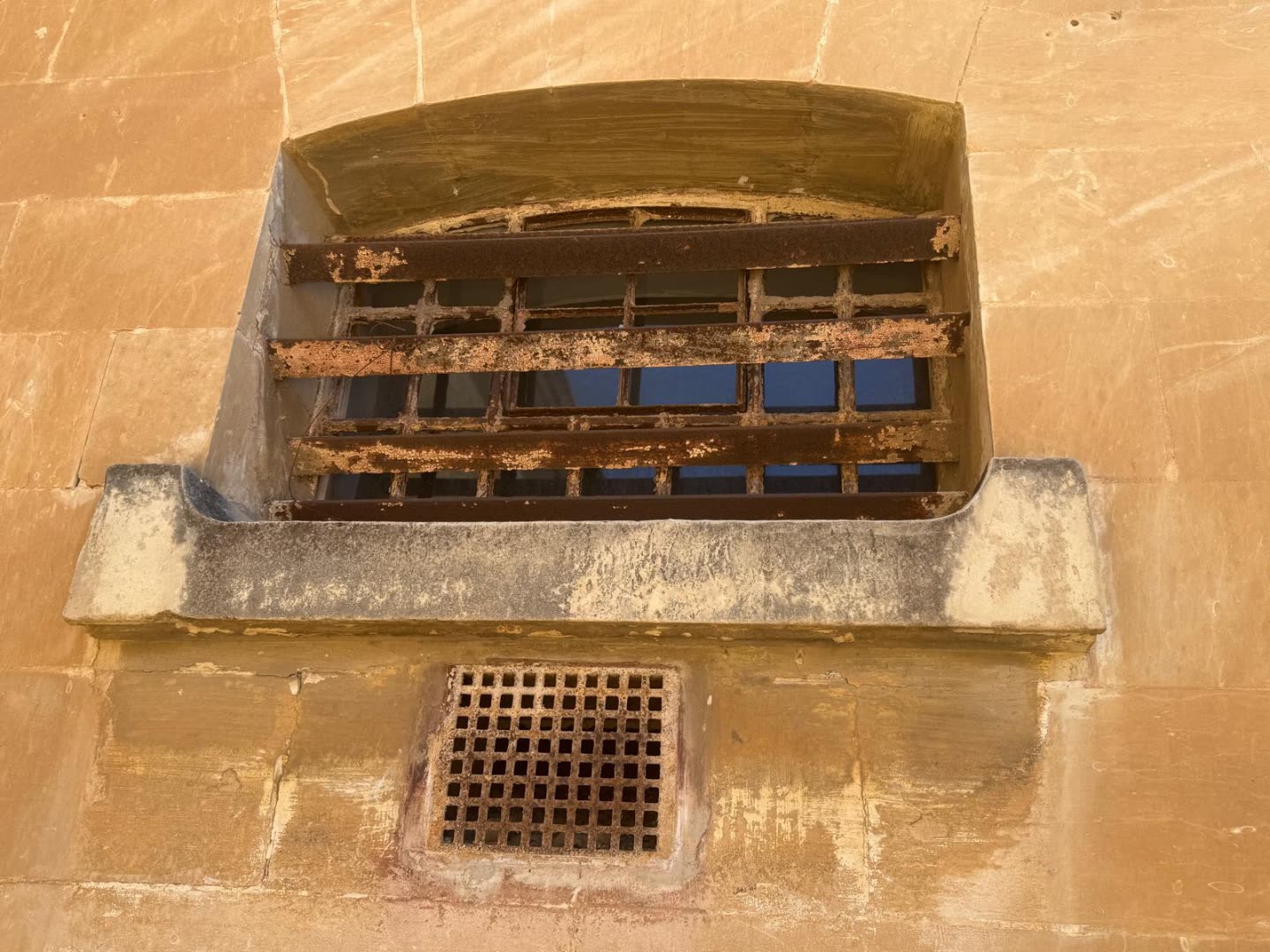 Barred window in weathered limestone