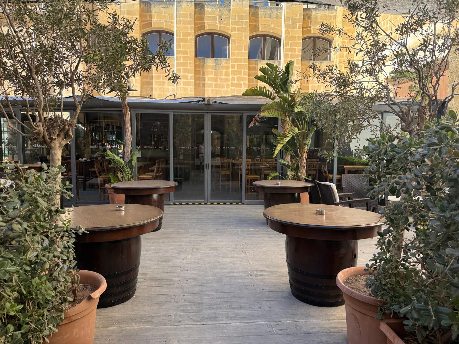 The Pavilion terrace — barrel tables in the yard